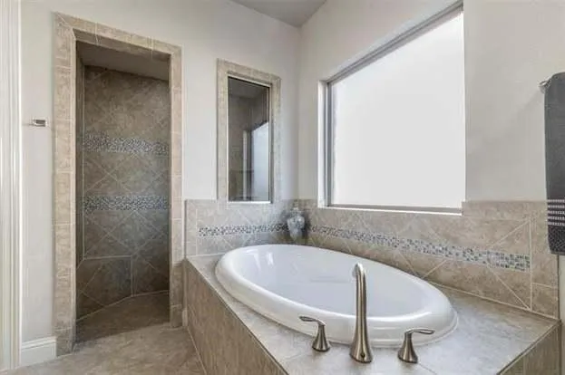 a white bath tub sitting in a bathroom next to a window