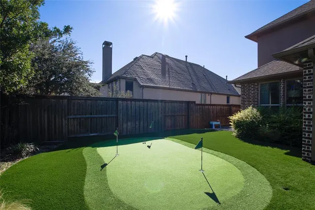 a view of a backyard with a small cabin and wooden fence