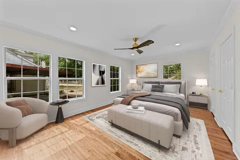 a bedroom with a large bed and windows