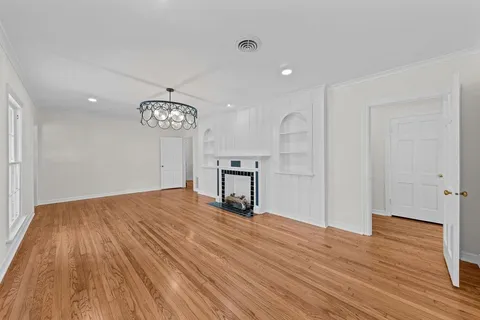 a view of a room with wooden floor and a ceiling fan