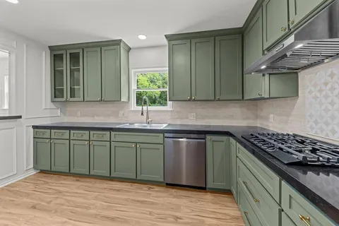 a kitchen with stainless steel appliances granite countertop a sink stove and cabinets