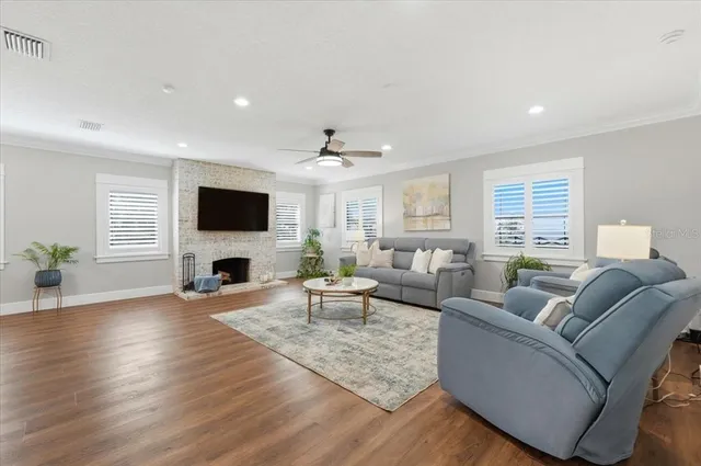 a large white kitchen with kitchen island a stove a sink a refrigerator and white cabinets with wooden floor