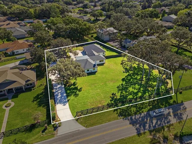 a front view of a house with a yard and potted plants
