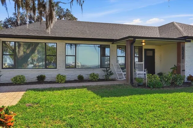 a living room with furniture and floor to ceiling windows