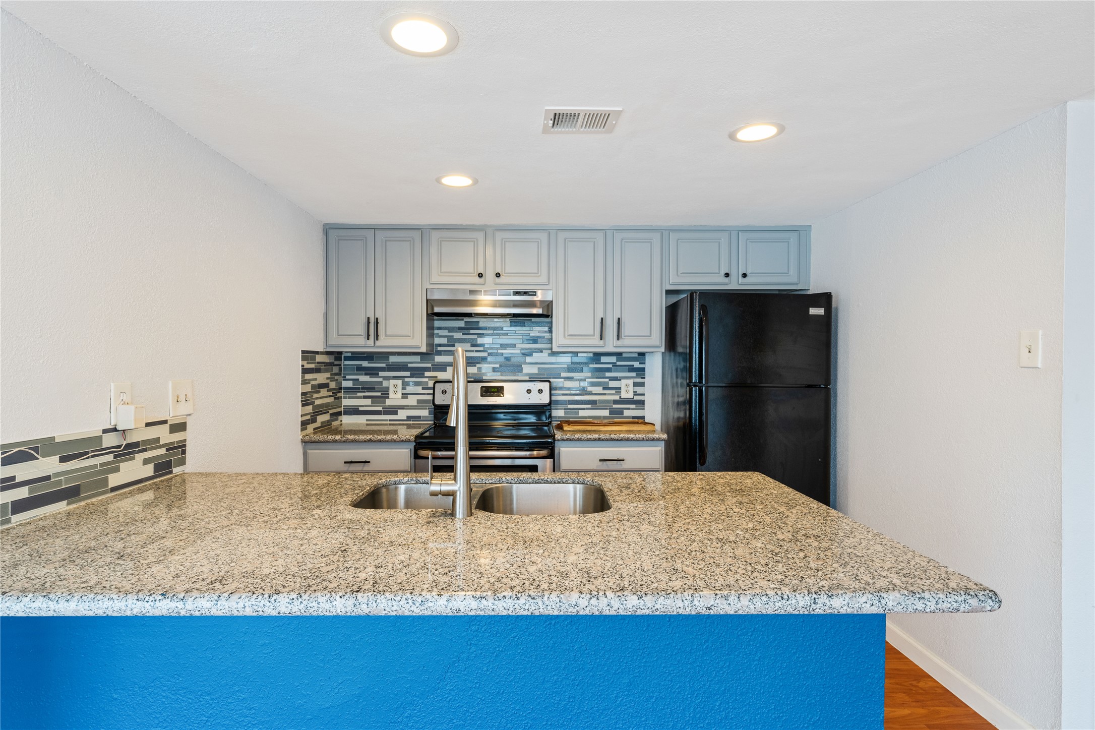 2124 Burton Drive, Unit 159 Austin, TX 78741 - Photo 9 of 23 A contemporary kitchen showcasing ample granite counters and a stylish tile backsplash.