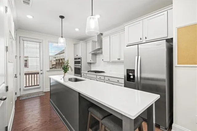 a kitchen with refrigerator and white cabinets