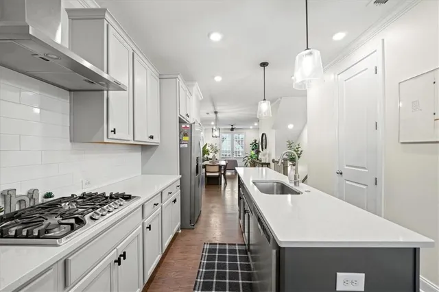 a kitchen with white cabinets sink and stainless steel appliances