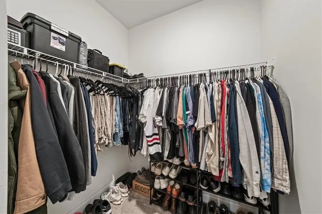 a view of walk in closet with clothes