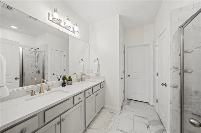 a bathroom with a double vanity sink mirror and shower