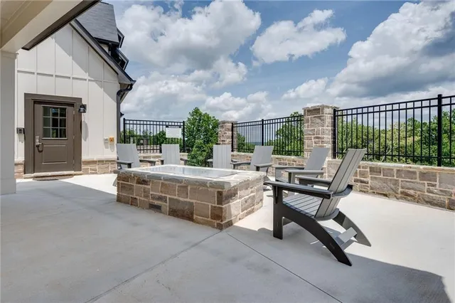 a swimming pool with outdoor seating and barbeque oven
