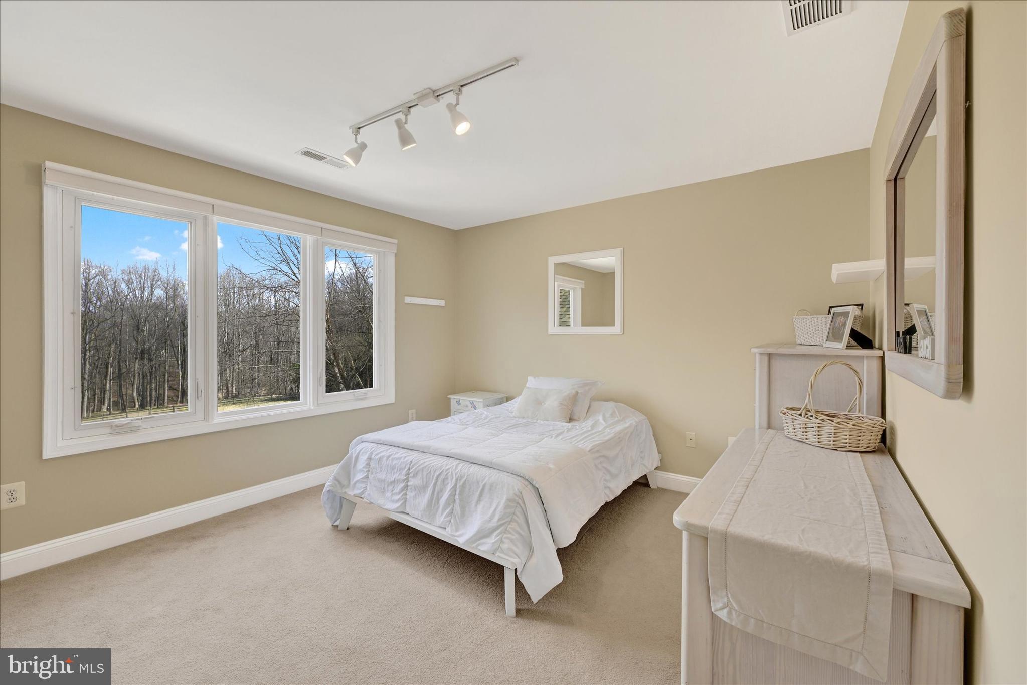9 Liberty Ridge Court Reisterstown, MD 21136 - Photo 21 of 42 a bedroom with a bed lamp and a large window