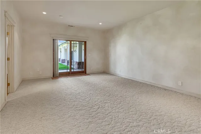 a view of a refrigerator in kitchen and an empty room