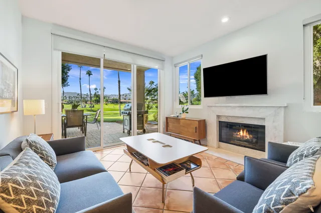 a living room with furniture a flat screen tv and a fireplace