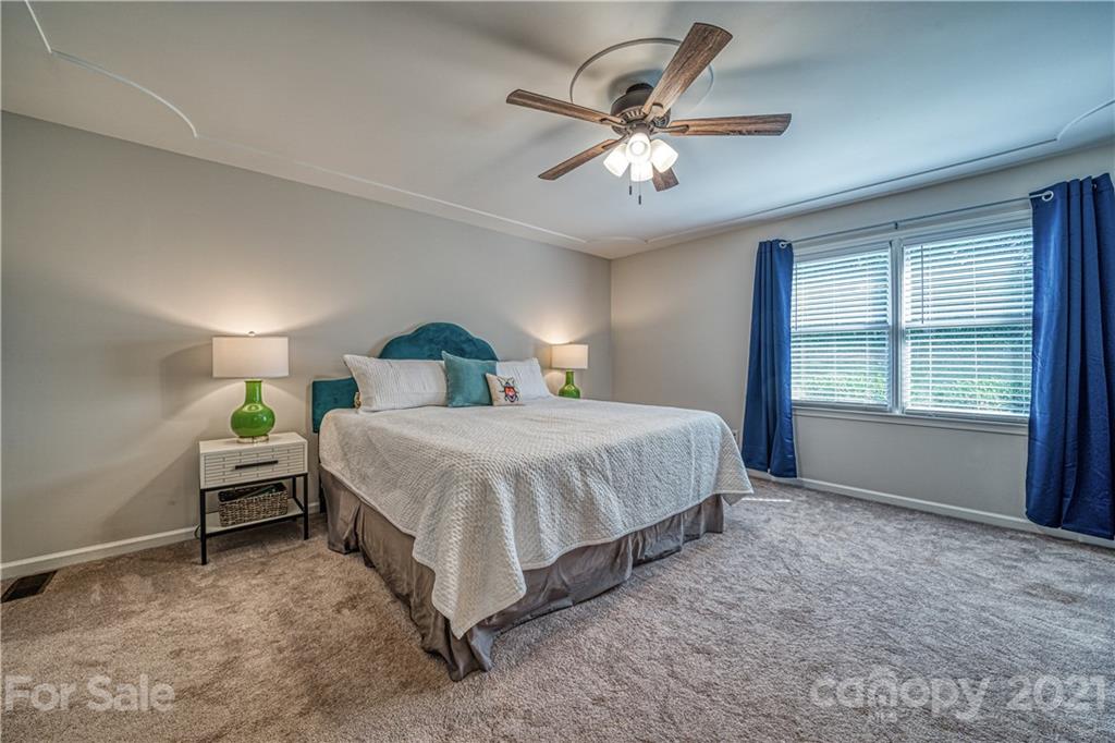 3705 River Road Hickory, NC 28602 - Photo 23 of 48 a spacious bedroom with a bed and a chandelier