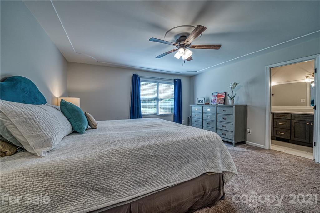 3705 River Road Hickory, NC 28602 - Photo 24 of 48 a bedroom with a large bed and a chandelier