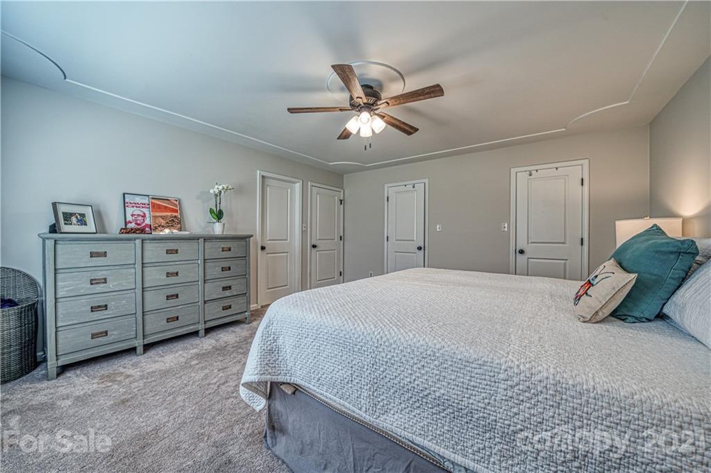 3705 River Road Hickory, NC 28602 - Photo 25 of 48 a spacious bedroom with a bed and a chandelier