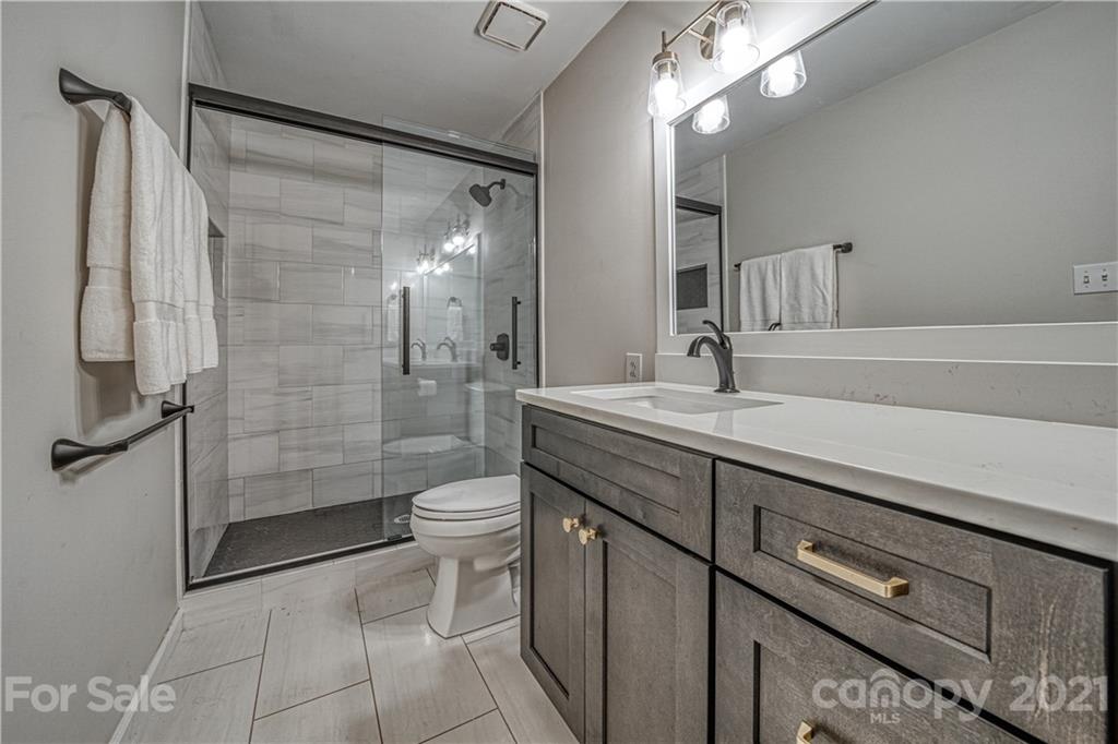 3705 River Road Hickory, NC 28602 - Photo 27 of 48 a bathroom with a double vanity sink toilet and shower