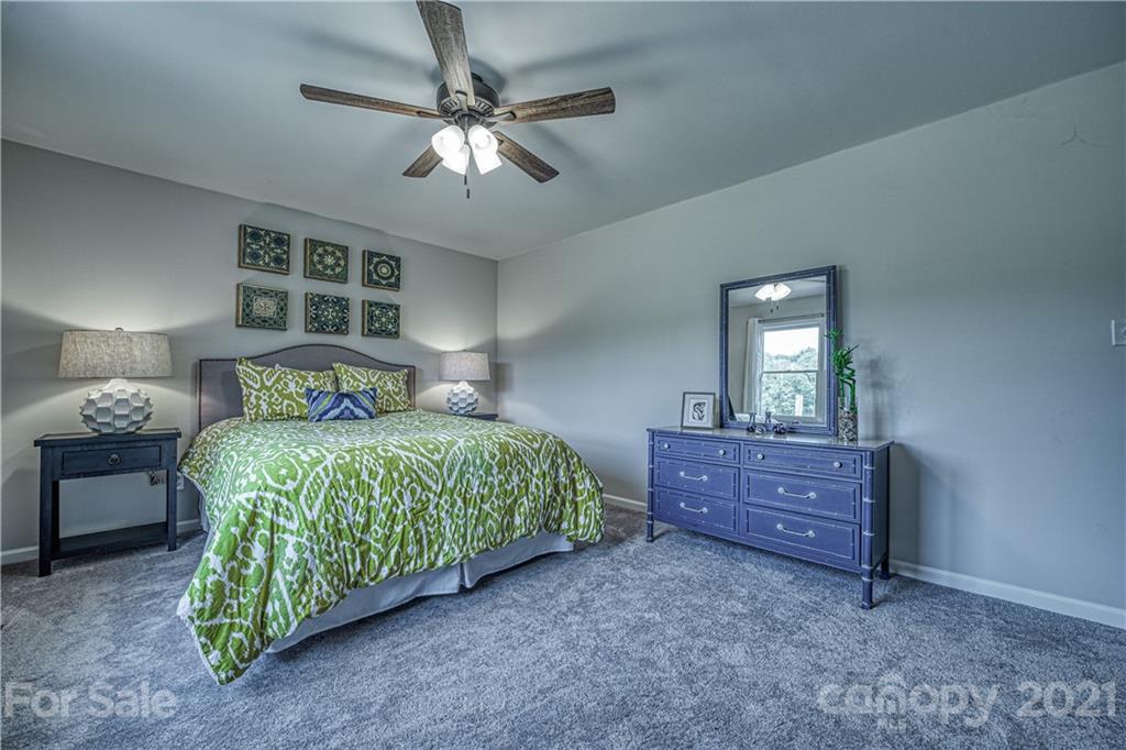 3705 River Road Hickory, NC 28602 - Photo 32 of 48 a bedroom with a bed and a chandelier