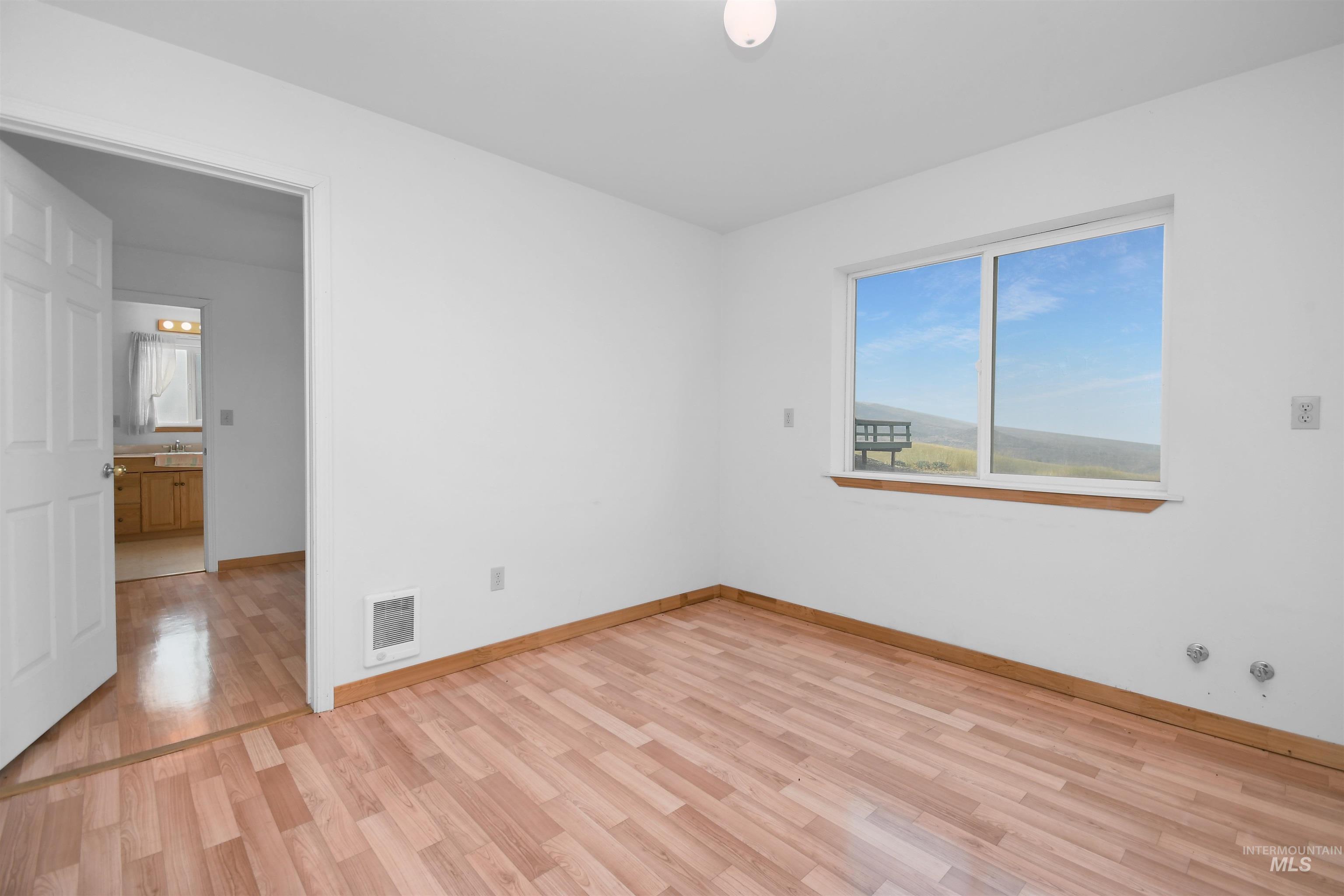 11375 Timber Butte Road Sweet, ID 83670 - Photo 41 of 49 Open interior space with wood-finish flooring, white walls, and a recessed baseboard heater