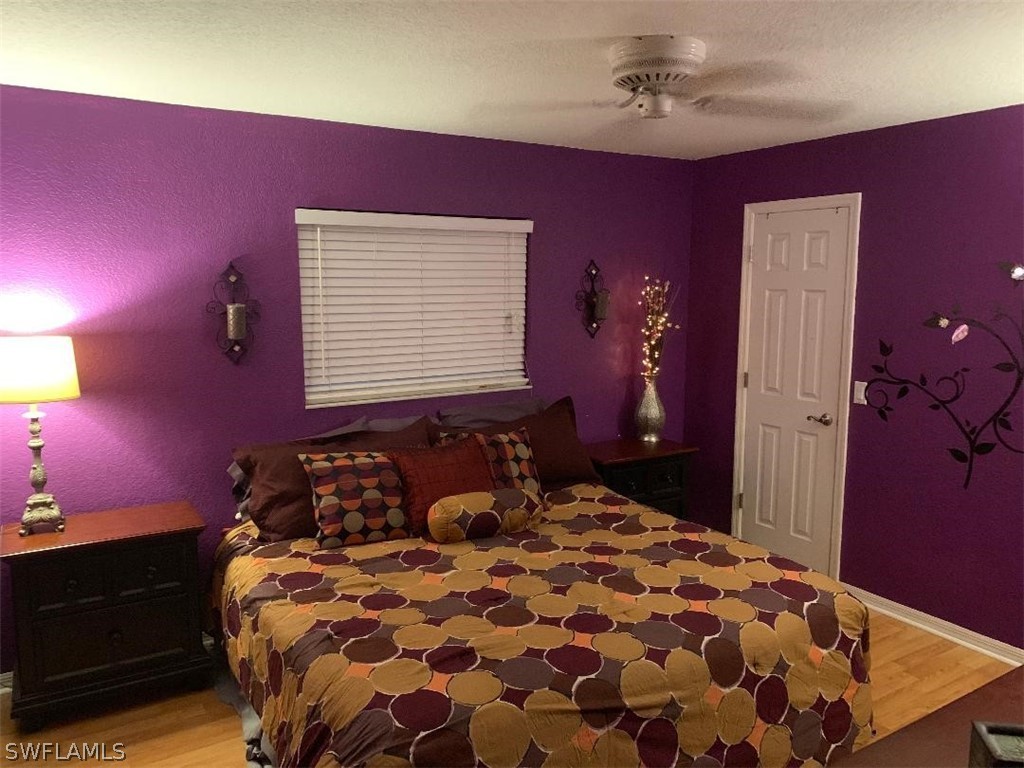 26324 Hong Kong Road Punta Gorda, FL 33983 - Photo 13 of 18 a bedroom with a bed and a chandelier