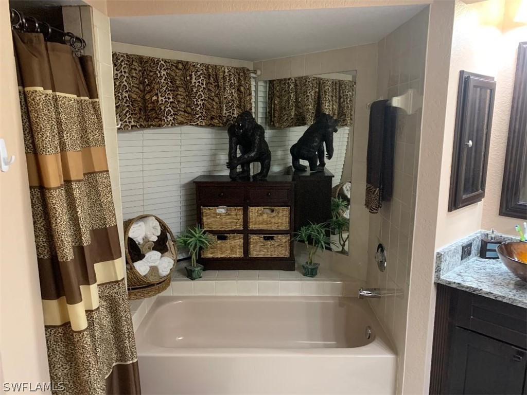 26324 Hong Kong Road Punta Gorda, FL 33983 - Photo 10 of 18 a bathroom with a tub sink and mirror