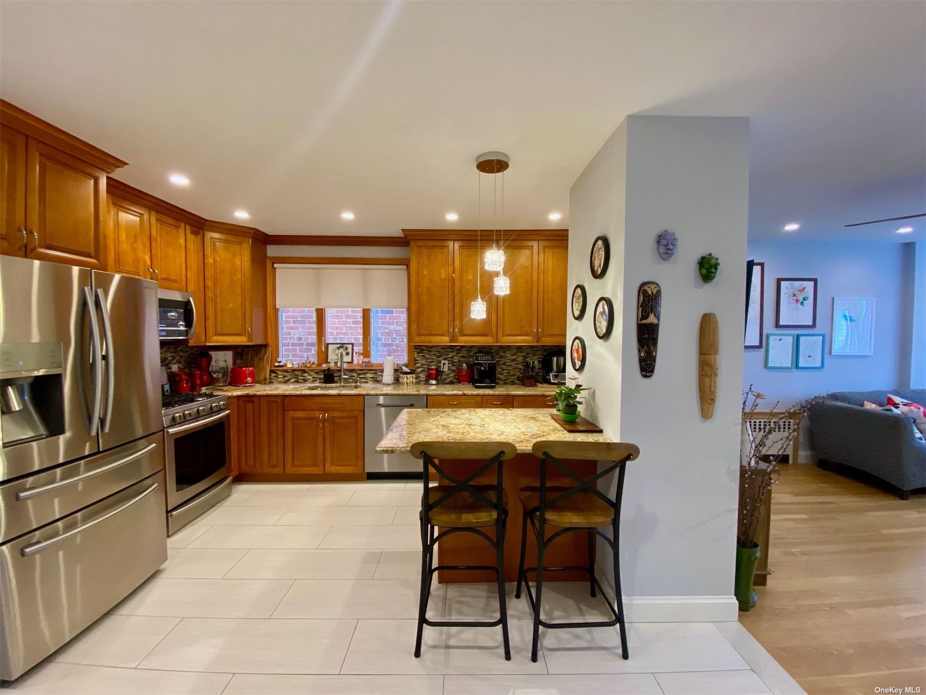 a kitchen with stainless steel appliances kitchen island granite countertop a refrigerator oven a sink a dining table and chairs with wooden floor