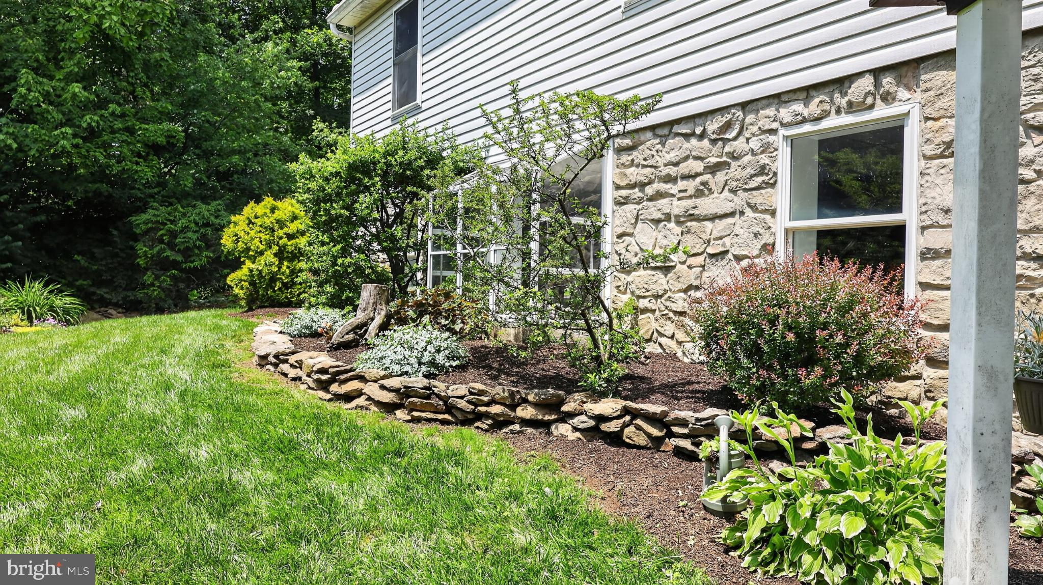 257 Hill Road New Holland, PA 17557 - Photo 36 of 94 Lush garden embraces charming stonework.