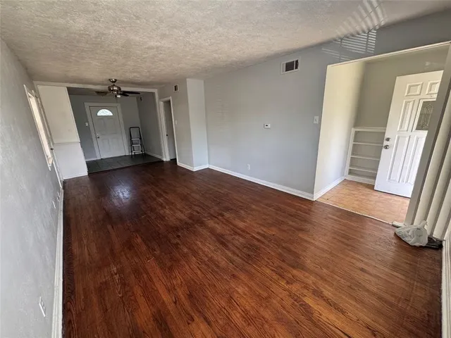 an empty room with wooden floor and entrance