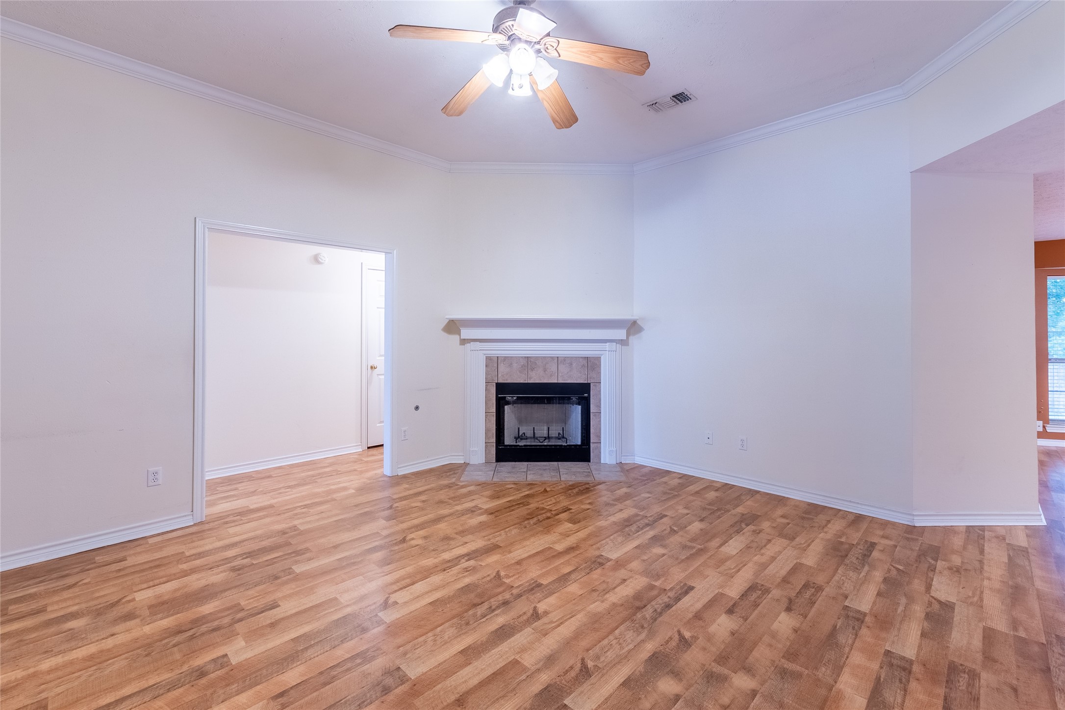 4802 Treadgold Lane Bryan, TX 77802 - Photo 6 of 28 a view of an empty room with wooden floor fireplace and a window
