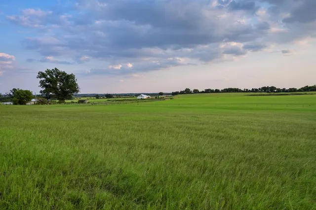a backyard of a house with lots of green space and lake view