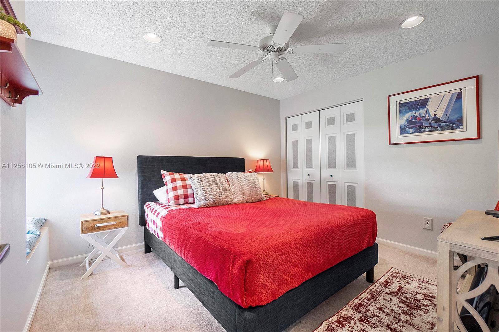 7677 Doubleton Drive Delray Beach, FL 33446 - Photo 16 of 42 a bedroom with a bed and a chandelier