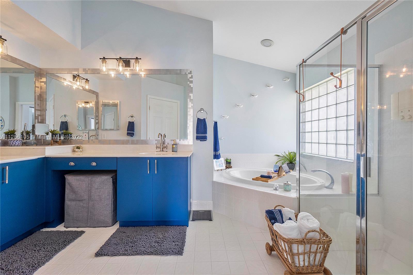 7677 Doubleton Drive Delray Beach, FL 33446 - Photo 23 of 42 a bathroom with a tub sink and a mirror