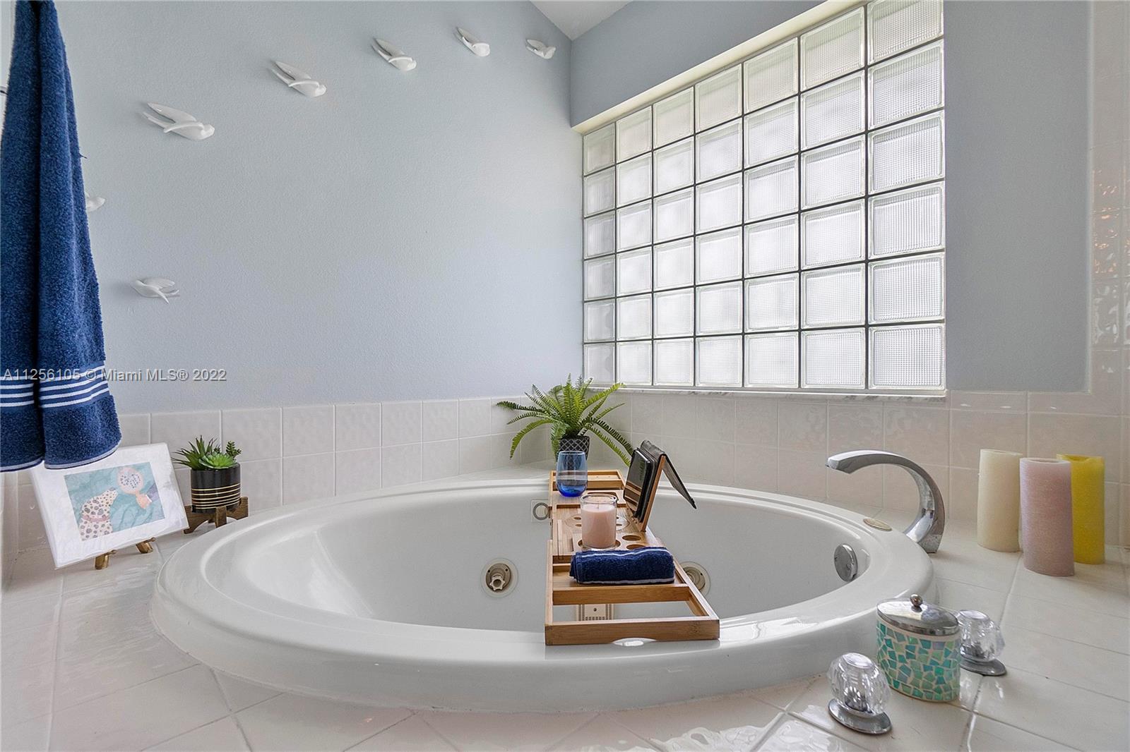 7677 Doubleton Drive Delray Beach, FL 33446 - Photo 26 of 42 a bathroom with a bathtub a sink and a window