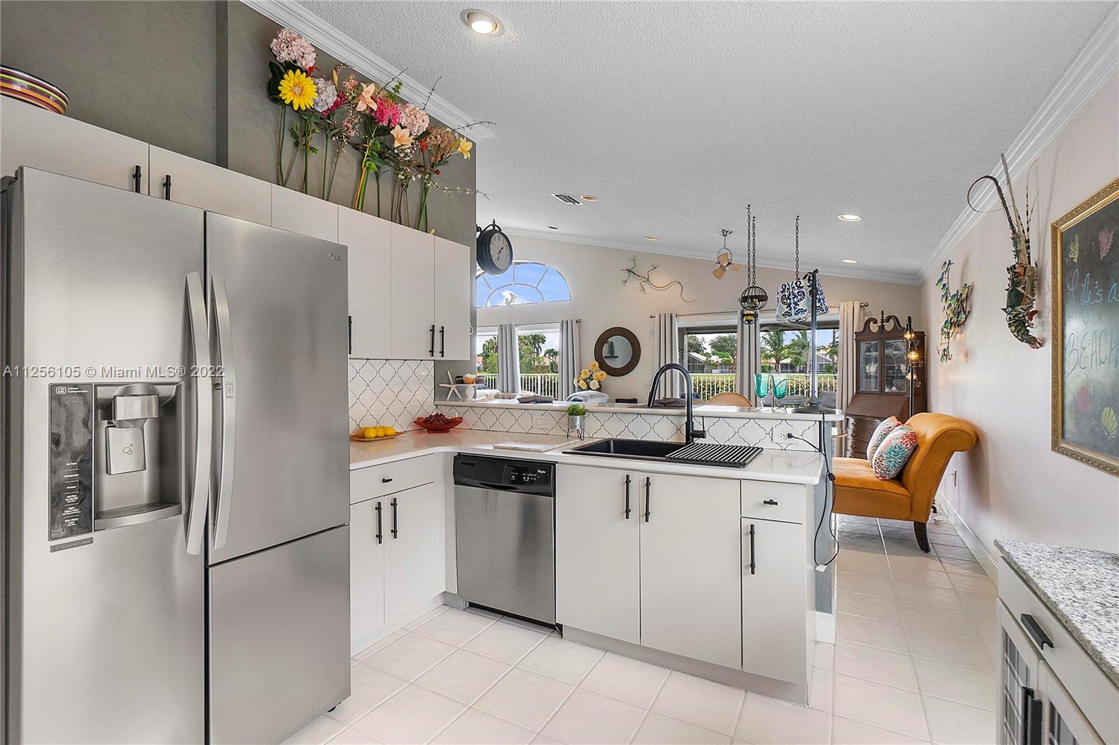 7677 Doubleton Drive Delray Beach, FL 33446 - Photo 33 of 42 a kitchen with stainless steel appliances a refrigerator a sink a stove and white cabinets