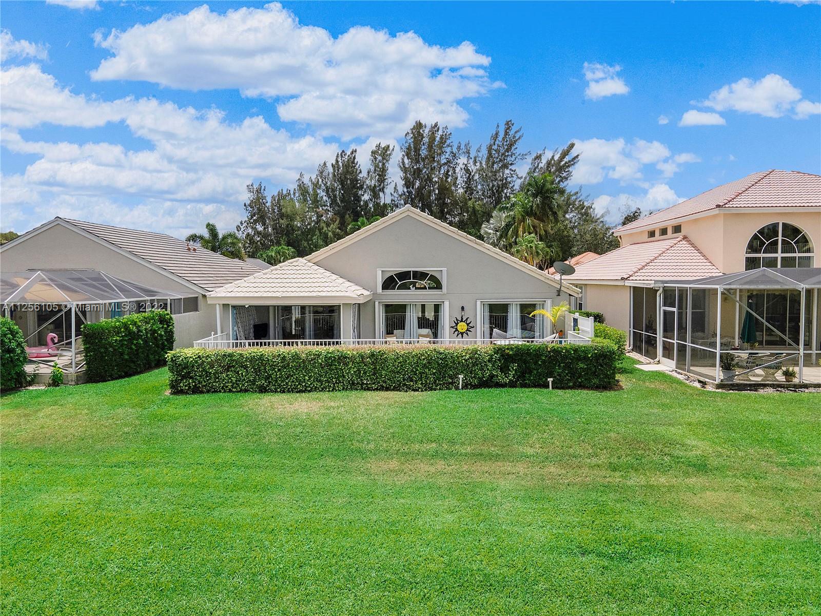 7677 Doubleton Drive Delray Beach, FL 33446 - Photo 7 of 42 a front view of a house with a garden