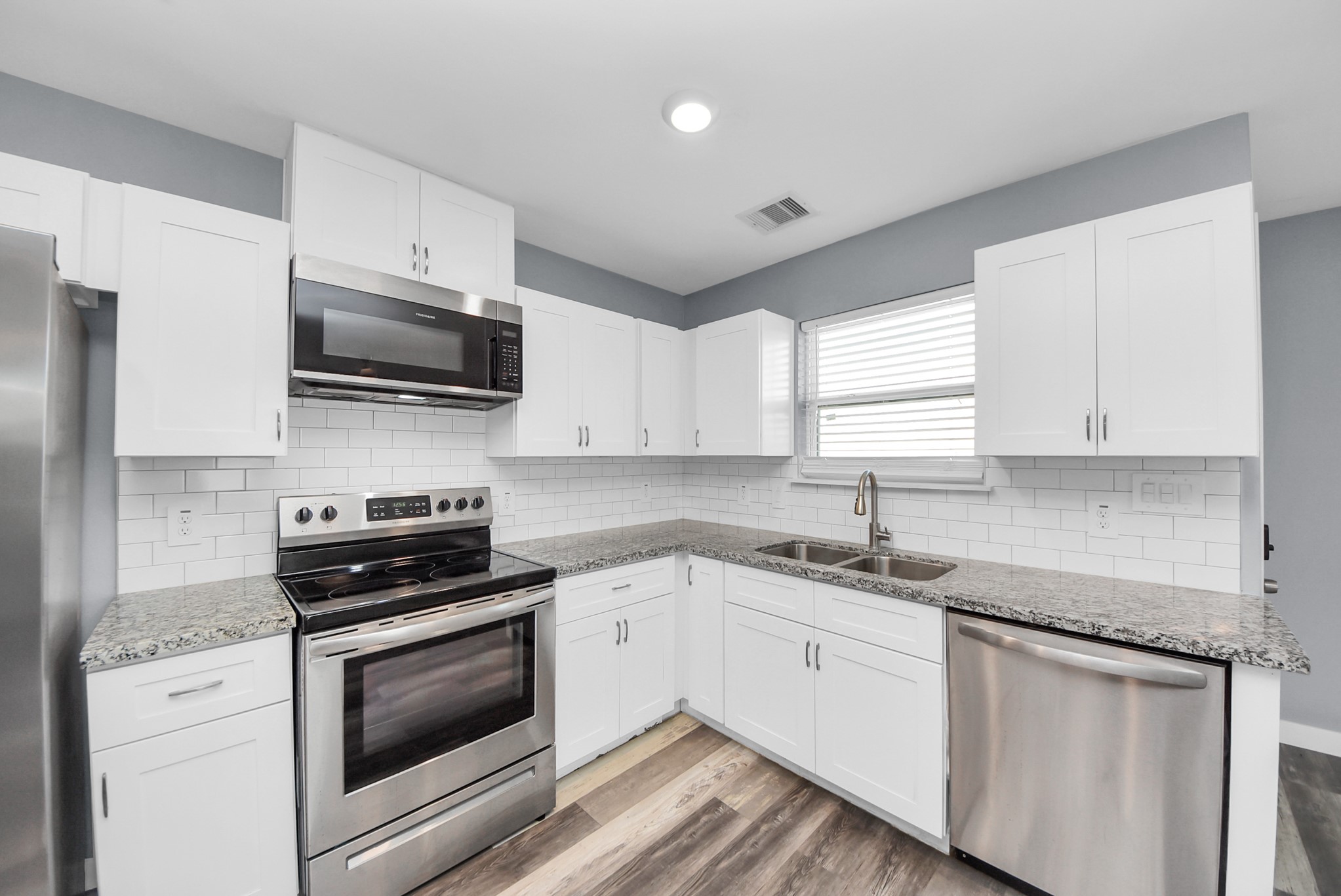 618 Maple Way, Unit A Houston, TX 77015 - Photo 7 of 48 a kitchen with granite countertop white cabinets appliances a sink and a window