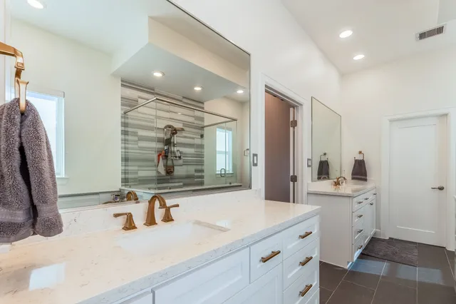 a bathroom with double vanity and a mirror