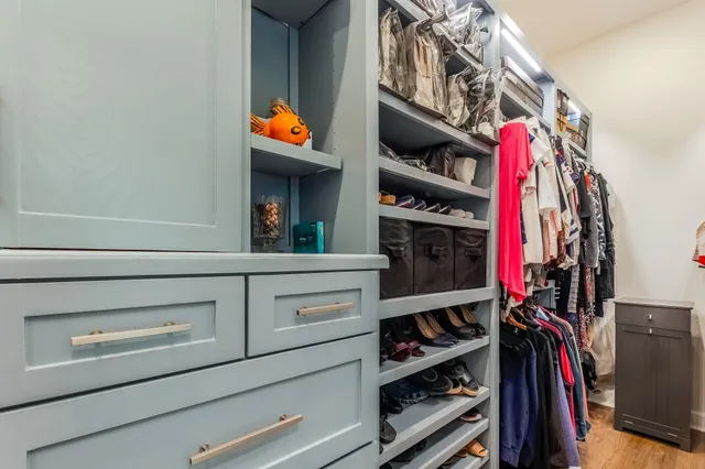 a view of walk in closet with clothes and shoes