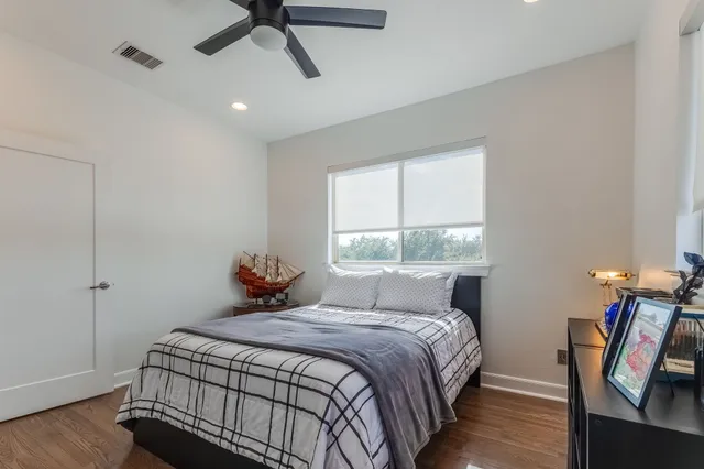 a bedroom with a bed a window and wooden floor