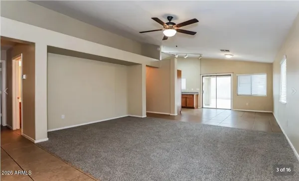an empty room with fan and windows