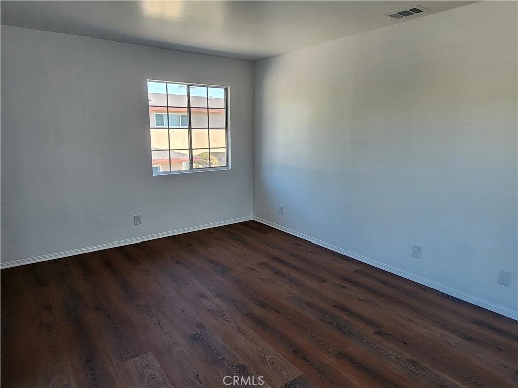 520 Claraday Street, Unit 1 Glendora, CA 91740 - Photo 8 of 16 an empty room with wooden floor and windows