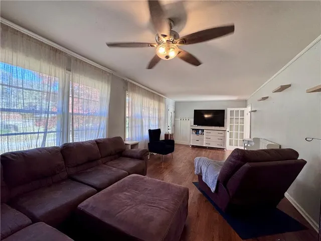 a living room with furniture a flat screen tv and a window