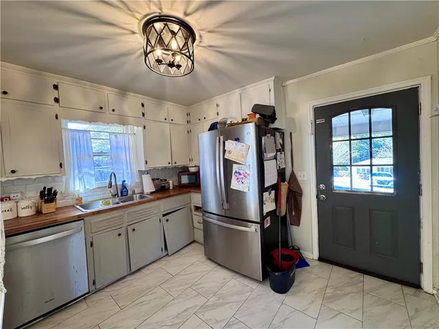 a kitchen with stainless steel appliances granite countertop a refrigerator and a sink