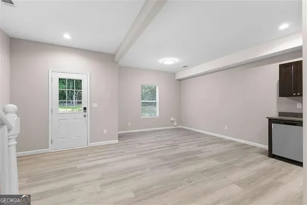 a view of empty room with kitchen and window