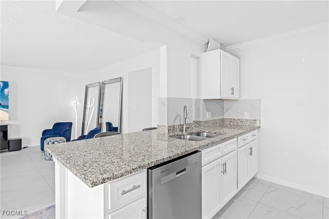 a kitchen with granite countertop a sink and white cabinets