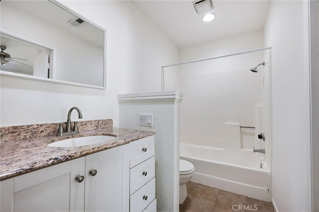 8167 Vineyard Avenue, Unit 47 Rancho Cucamonga, CA 91730 - Photo 22 of 22 a bathroom with a granite countertop sink a toilet and bathtub