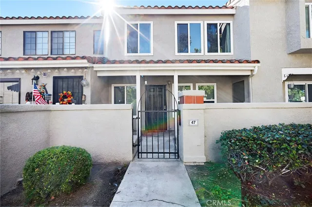 a front view of a house with a lots of windows and plants