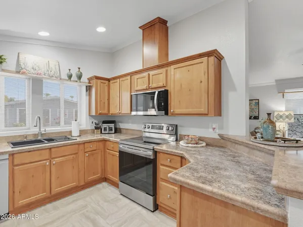 a very nice looking open dining room with kitchen island granite countertop a sink a stove and a chandelier