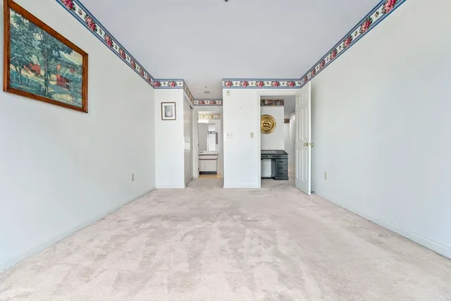a view of an empty room with closet and a window