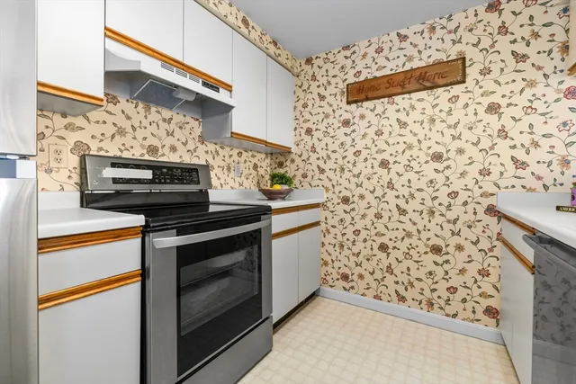 a kitchen with stainless steel appliances wooden cabinets and a stove top oven